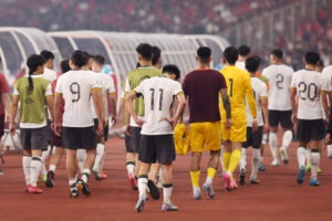 Dejected members of China's men's football team walk off the field after losing to Indonesia 0-1, in a World Cup qualifying match. China shifts focus to esports team after World Cup qualifying exit